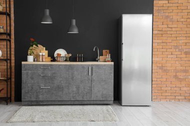 Modern buzdolabı, tezgah ve lambalı mutfağın içi.