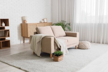 Işık perdesi ve kanepesi olan oturma odasının içinde.