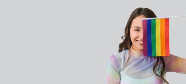 Açık arkaplanda LGBT bayrağı ve metin için alanı olan genç bir kadın