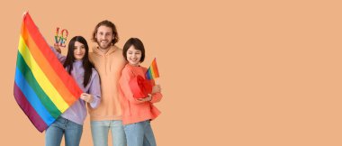 LGBT bayraklı erkek ve iki kadın bej arka planda hediye ve kelime aşkı ve metin için boşluk