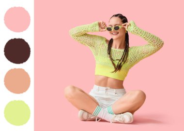 Örgü ören, güneş gözlüklü, pembe arka planda oturan zarif genç bir kadın.