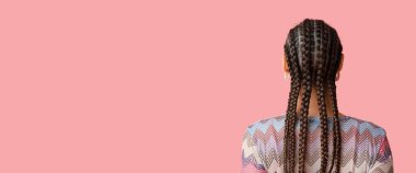 Pembe arka planda örgülü genç bir kadın. Mesaj ve arka plan için yeri var.