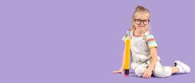 Büyük kalemi olan, leylak arka planda oturan sevimli küçük kız öğrenci.