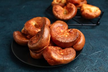 Mavi arka planda lezzetli Yorkshire pudingi olan tabak.