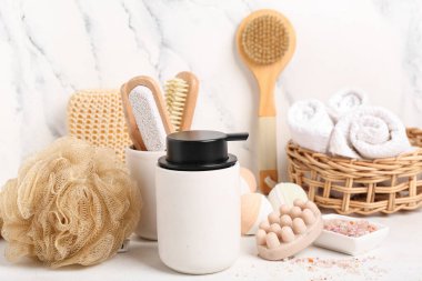 Arka planda masaj fırçası olan farklı banyo malzemeleri.