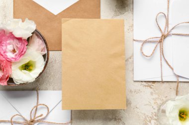 Zarflı kompozisyon, boş kartlar ve bej arka planda östoma çiçekleri, yakın plan. Düğün davetiyesi konsepti