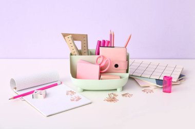 Işık masasında farklı kırtasiye malzemesi ve defterleri olan tutucu