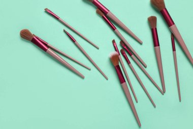 Turkuaz arka planda makyaj fırçaları