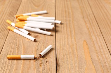 Ahşap arka planda dağınık tütünlü sigaralar, yakın plan. Akciğer kanseri kavramı