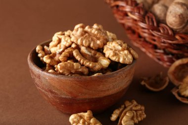 Kahverengi arka planda bir kase lezzetli ceviz.