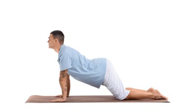 Genç adam beyaz arka planda yoga yapıyor.
