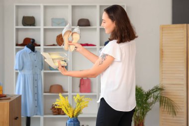 Giyim mağazasında şık ayakkabıları olan bir kadın satıcı.