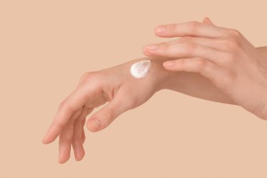 Renkli arka planda doğal kremi olan kadın elleri, yakın plan