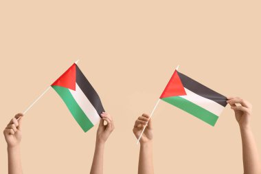 Bej arka planda Filistin bayrakları olan kadın elleri