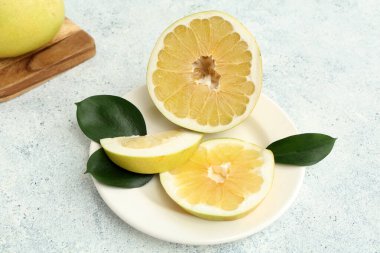 Kesik taze meyve ve beyaz arkaplanda yapraklar