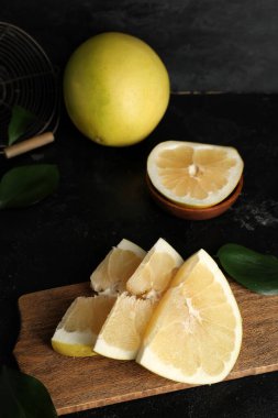 Tahta tahtada siyah arka planda taze nar meyvesi parçaları var.