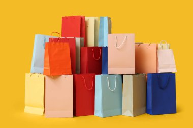 Sarı arka planda bir sürü alışveriş torbası