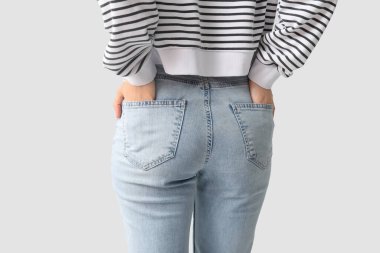 Gri arka planda şık kotlu genç bayan, yakın plan.