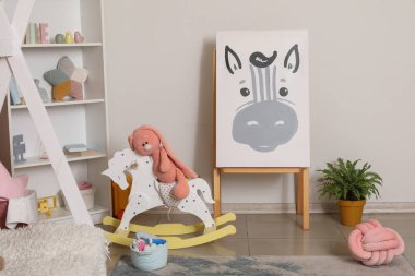 Çocuk odasının içinde oyuncak tavşan sallanıyor.