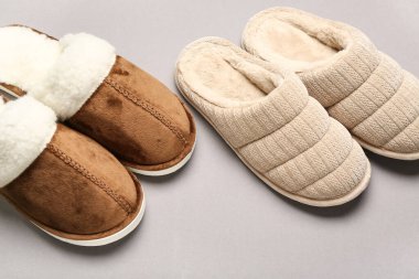 Gri arka planda iki çift yumuşak terlik.