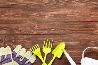 Kahverengi ahşap arka planda bahçe işleri için araçlar. Üst görünüm