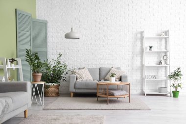 Rahat kanepesi, lambası ve raf ünitesi olan şık bir oturma odası.