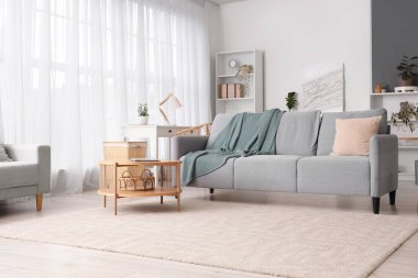 Rahat kanepesi, sehpası ve battaniyesi olan bir oturma odası.