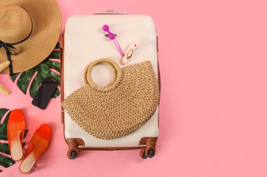 Çantalı kompozisyon, plaj aksesuarları, cep telefonu ve pembe arka planda seks oyuncakları.