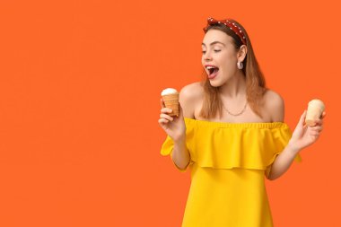 Şaşırmış genç bir kadın turuncu arka planda vanilyalı dondurma tutuyor.