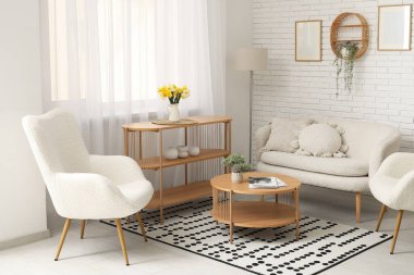 Oturma odasında rahat bir kanepe, koltuklar ve kahve masası var.