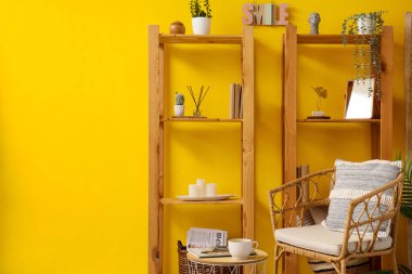 Ahşap raf üniteleri ve koltuğu olan oturma odasının içinde.