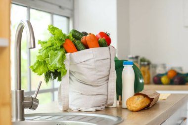 Mutfak lavabosunun yanında bir alışveriş çantası.