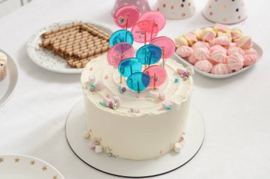 Beyaz masada doğum günü partisi için şekerli pasta.