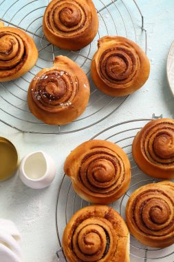 Tatlı tarçınlı çörekler ve açık mavi arka planda süt sürahisi