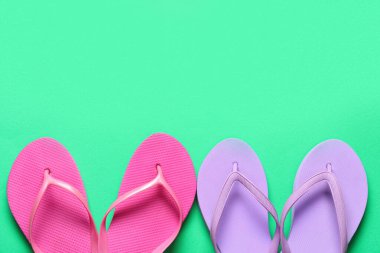 Yeşil arkaplanda farklı parmak arası terlikler