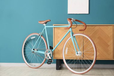 Mavi duvarın yanındaki çekmece, resim ve bisiklet sandığı.