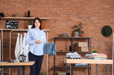 Erkek giyim mağazasında kot pantolon giyen kadın satıcı.