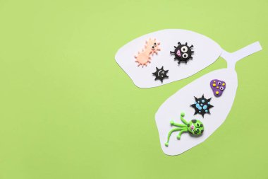 Yeşil arka planda plastik virüslü kağıt akciğerler