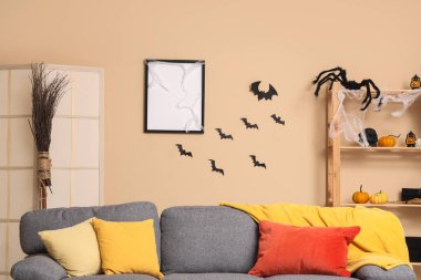 Cadılar Bayramı için kanepeyle dekore edilmiş modern oturma odasının içi.