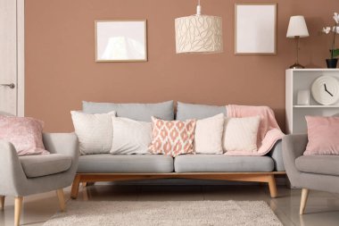 Oturma odasının içinde lambalar, kanepe ve koltuklar var.