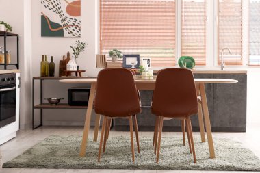 Ahşap yemek masası, mutfak içi sandalyeler ve tezgahlar.