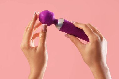 Pembe arka planda vibratörü ve kayganlaştırıcısı olan kadın.