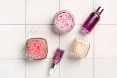 Farklı önlükler, temel yağ ve arka planda kozmetik kremi