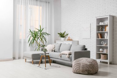 Oturma odasındaki kanepe, puf, kahve masası ve bitkiler.