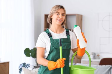 Evde paspas ve deterjanı olan güzel bir kadın.