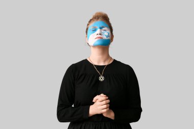 Yüzünde İsrail bayrağı olan dua eden genç bir kadın. Uluslararası Soykırım Anma Günü