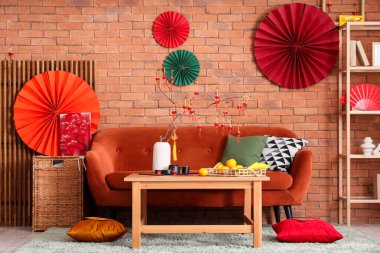 Çin Yeni Yıl kutlamaları için kırmızı kanepe, masa ve dekorla oturma odasının içinde.