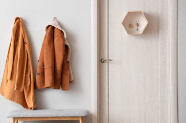 Ceketli, kapılı, gri banklı ve anahtarlı şık bir salon.