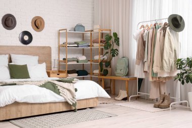 Şık bir yatak odası, rahat bir yatak odası ve elbise askısı.