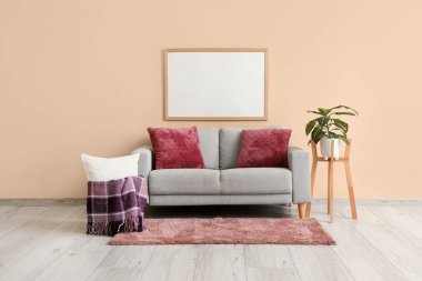 Mor ekoseli, çiçekli ve gri kanepeli modern oturma odasının içi.